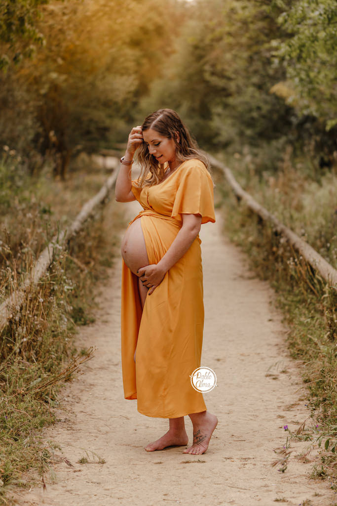 Foto de Embarazada en Exterior en el campo en el atardecer con vestido color mostaza
