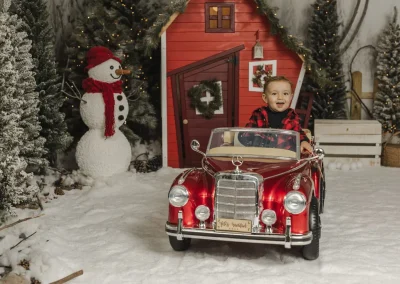 Foto bebé Navidad en coche rojo descapotable